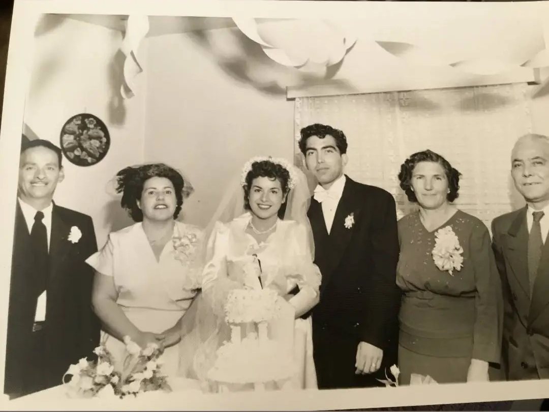 Black-and-white 1950s wedding photo of the Ponce family — five relatives dressed formally together at a wedding celebration